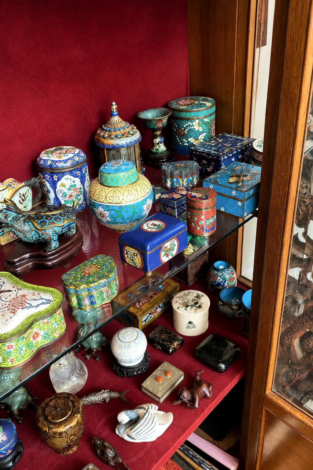 Kleine Cloisonné- und Kunstobjekte in einer Vitrine aus Batjas Sammlung
